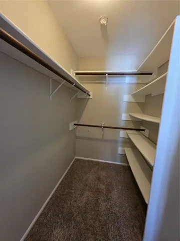 a view of walk in closet with empty racks