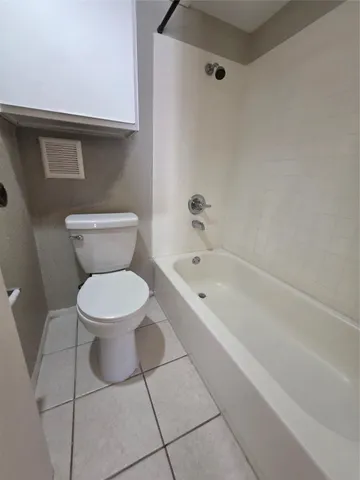 a white toilet sitting next to a bath tub