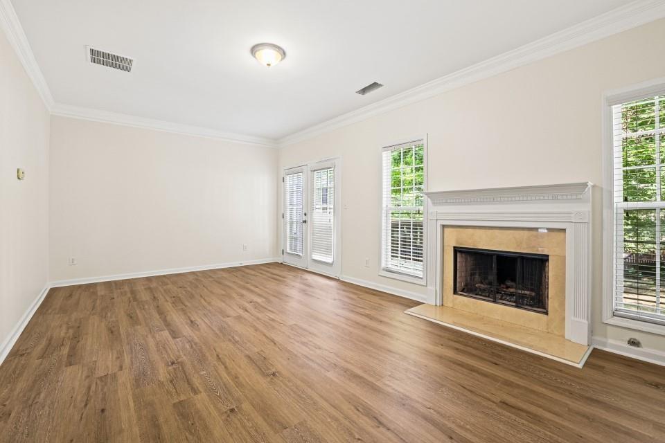 810 Ash Street Canton, GA 30114 - Photo 3 of 16 an empty room with wooden floor fireplace and windows