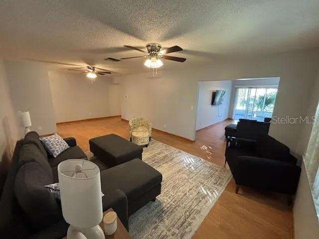 a living room with furniture and a ceiling fan