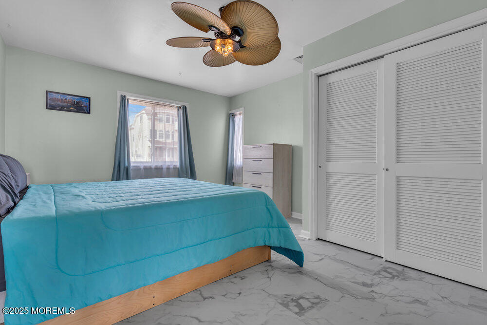 1604 Beach Boulevard Forked River, NJ 08731 - Photo 64 of 108 a bedroom with a bed and a chandelier