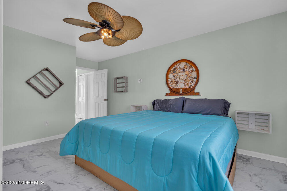 1604 Beach Boulevard Forked River, NJ 08731 - Photo 65 of 108 a bedroom with a bed and a chandelier