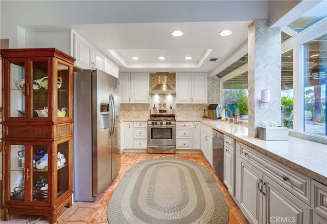 a kitchen with stainless steel appliances granite countertop a refrigerator and a sink