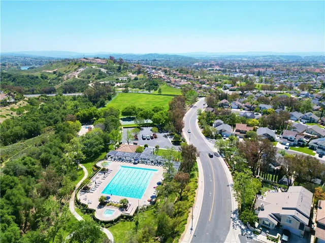 an aerial view of residential houses with outdoor space and trees
