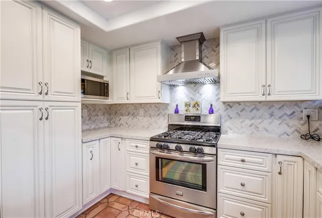 a kitchen with white cabinets and appliances