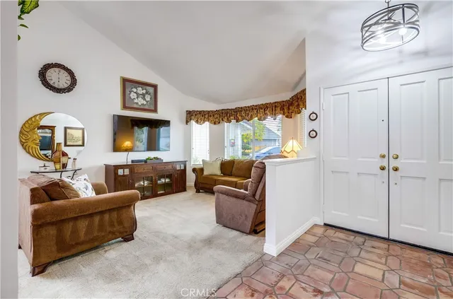 a view of a dining room and livingroom with furniture a rug a potted plant and a chandelier