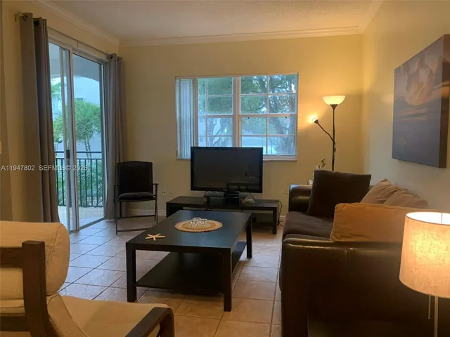 a living room with furniture a lamp and a flat screen tv