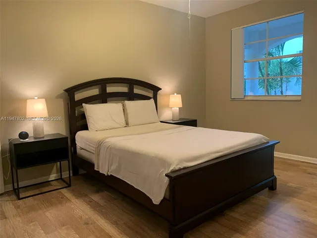 a bedroom with a bed and a lamp on dresser