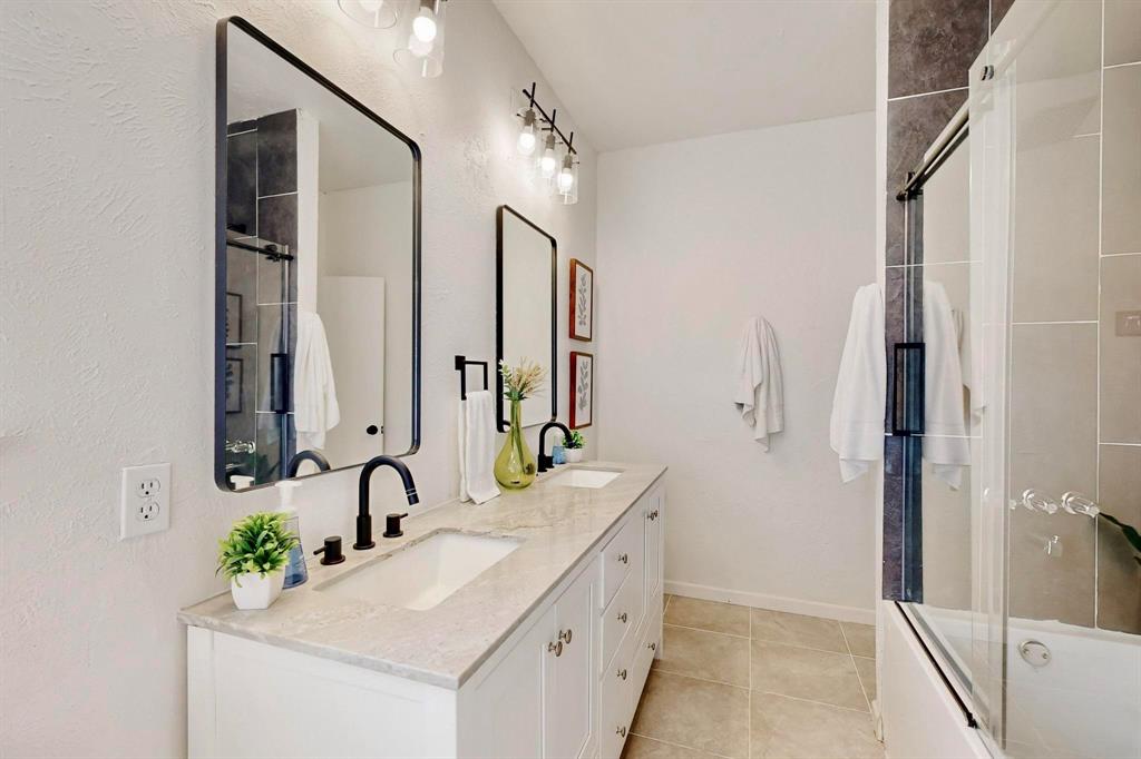 3965 Singleleaf Lane Fort Worth, TX 76133 - Photo 26 of 39 Dual vanity with white cabinetry, light-toned countertop, and matte black fixtures