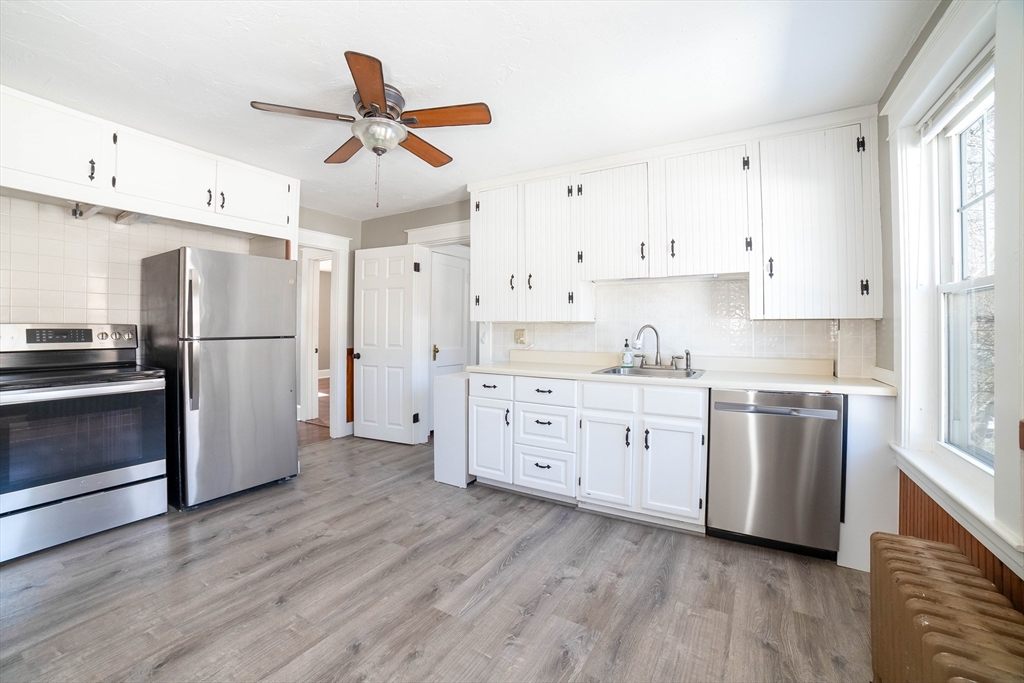 5 Maple Avenue, Unit 2 Oxford, MA 01537 - Photo 11 of 22 a kitchen with stainless steel appliances white cabinets and wooden floors