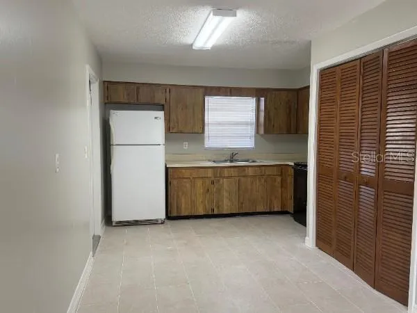 a kitchen with a stove a refrigerator a sink and dishwasher with white cabinets