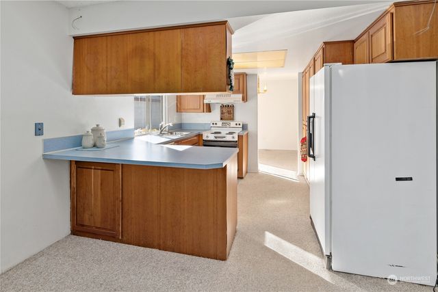 a kitchen with stainless steel appliances granite countertop a stove a sink and a refrigerator