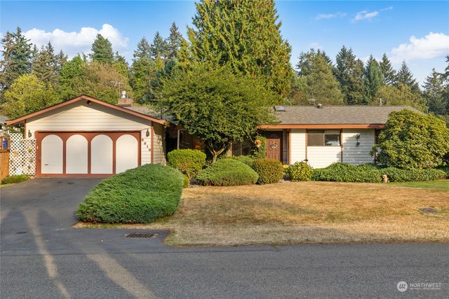 a front view of a house with yard and green space
