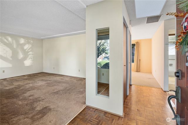 a view of a hallway to a livingroom with furniture