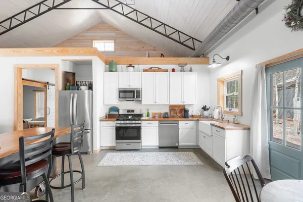 a kitchen with stainless steel appliances a stove a sink and a microwave