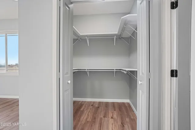 a view of walk in closet with empty racks