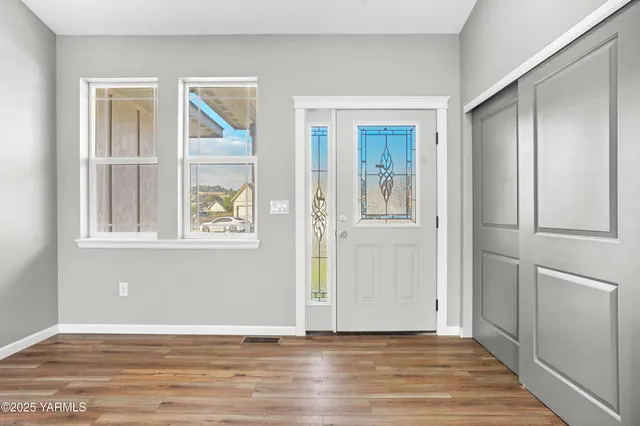 an empty room with wooden floor and windows