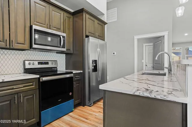 a kitchen with stainless steel appliances a stove microwave and refrigerator