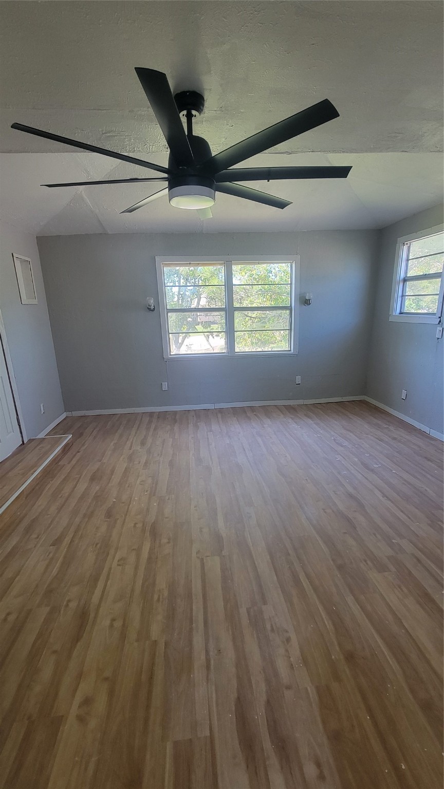 12018 Sandpiper Road Angleton, TX 77515 - Photo 17 of 48 an empty room with wooden floor ceiling fan and windows