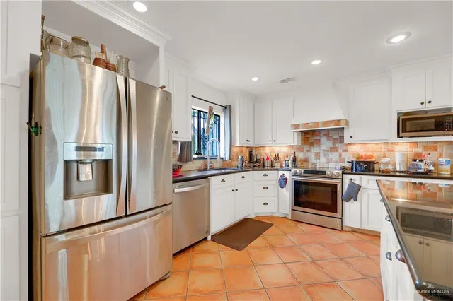 a kitchen with granite countertop stainless steel appliances and refrigerator