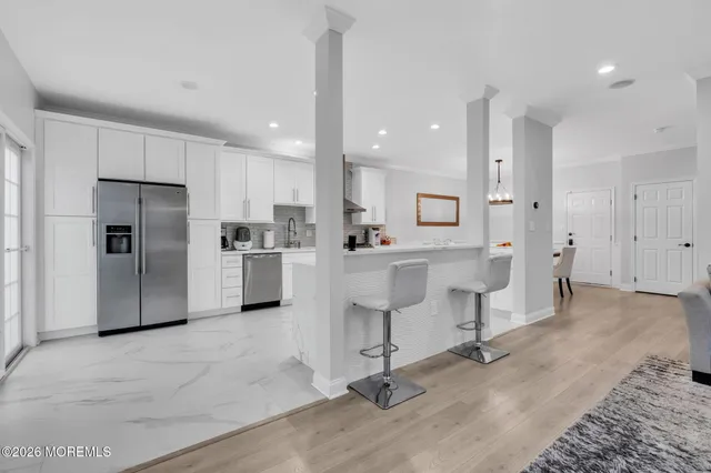 a kitchen with stainless steel appliances kitchen island granite countertop a refrigerator and a sink