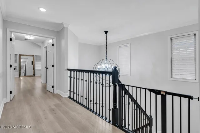 a view of a hallway with wooden floor and stairs
