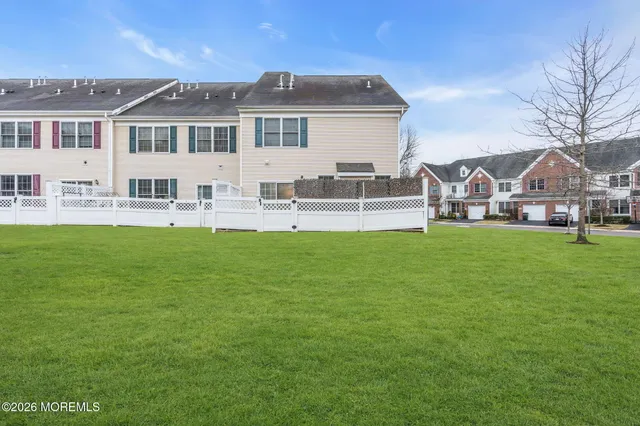 a front view of a house with a garden and trees