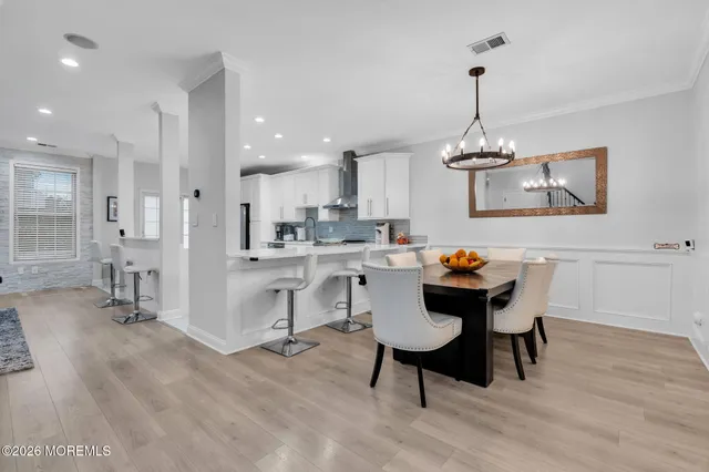 a kitchen with a dining table chairs and white cabinets