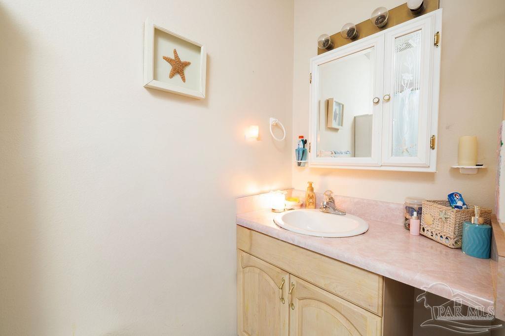 1590 Jacks Branch Road Cantonment, FL 32533 - Photo 5 of 19 a bathroom with a sink vanity and a mirror
