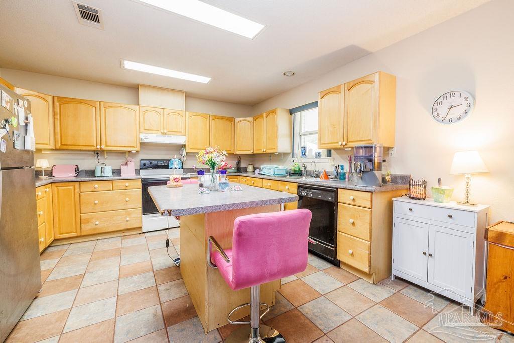 1590 Jacks Branch Road Cantonment, FL 32533 - Photo 8 of 19 a kitchen with stainless steel appliances kitchen island granite countertop a sink dishwasher and white cabinets with wooden floor
