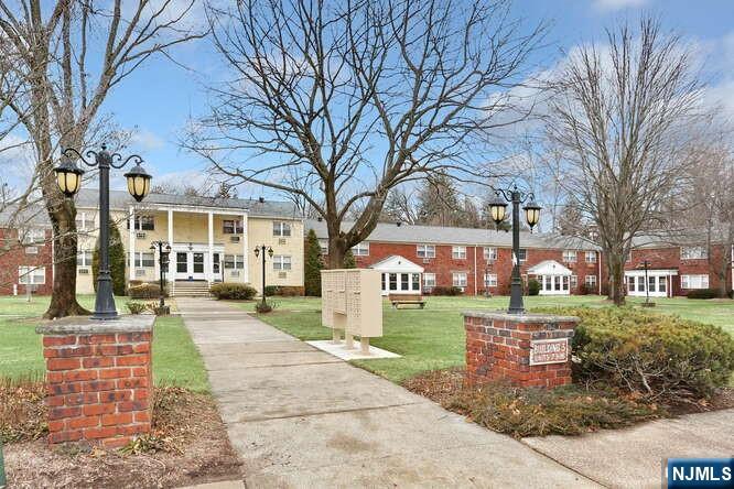 95 Regency Park, Unit 95 Ramsey, NJ 07446 - Photo 2 of 13 a front view of a building with a garden and trees