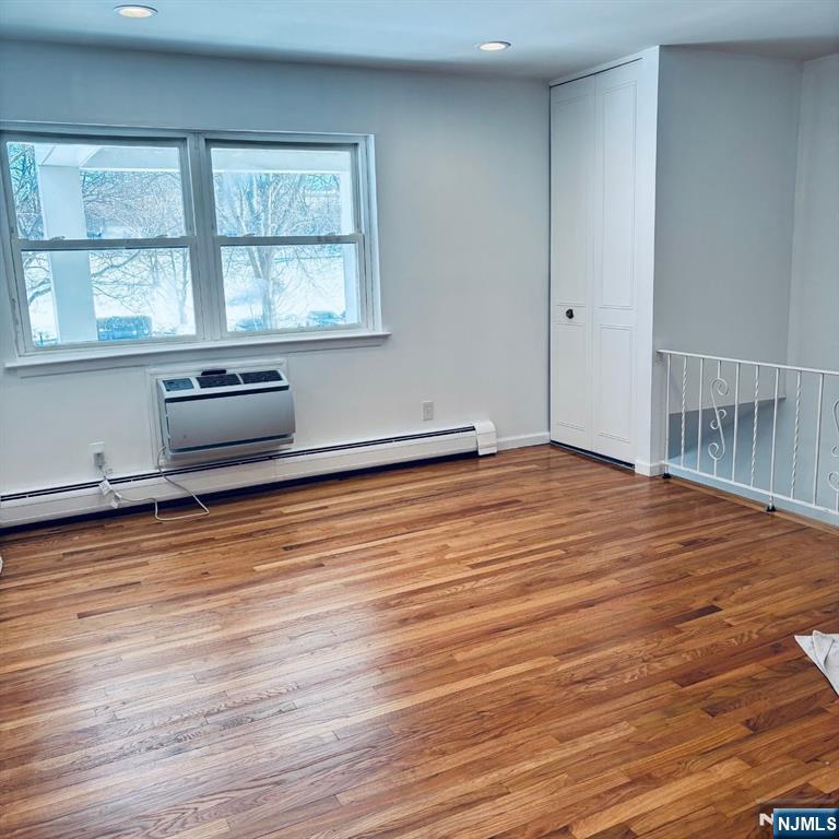 95 Regency Park, Unit 95 Ramsey, NJ 07446 - Photo 5 of 13 an empty room with wooden floor and windows