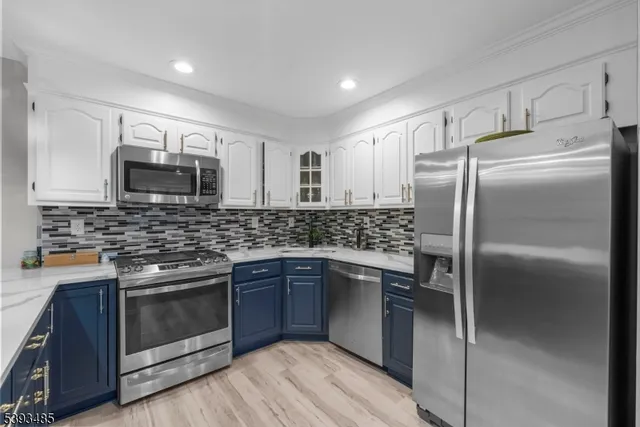 a kitchen with stainless steel appliances granite countertop a stove top oven microwave and refrigerator