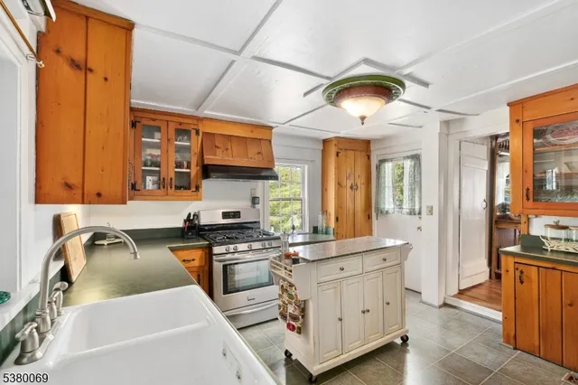 a kitchen that has a sink a stove and cabinets