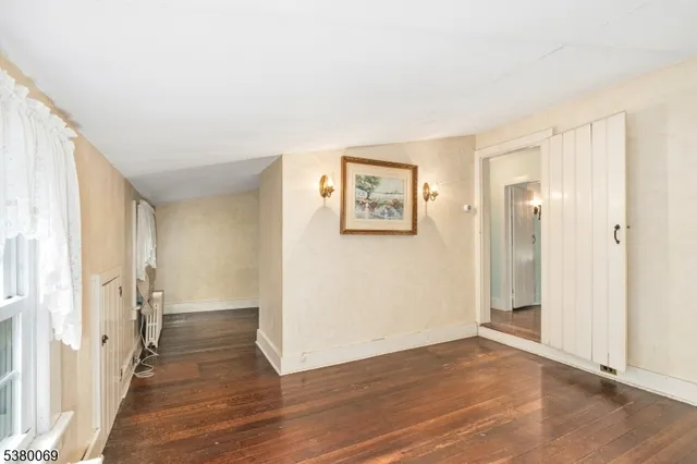 a view of a big room with wooden floor and windows