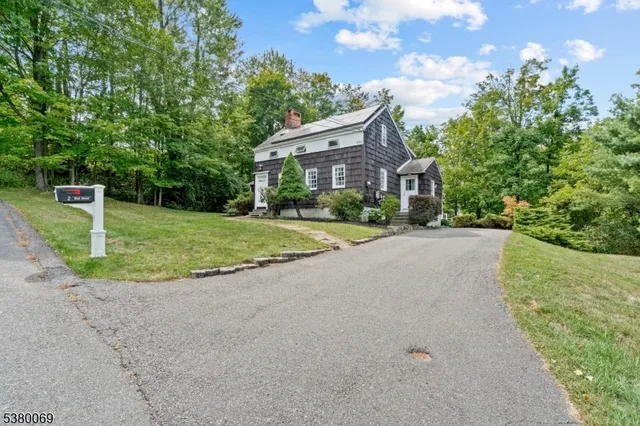 a view of a house with a yard and large tree