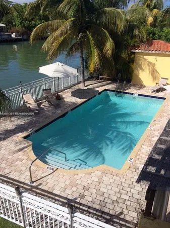 a view of swimming pool with lawn chairs and plants