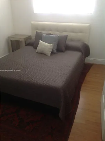 a bed sitting in a bedroom next to a lamp