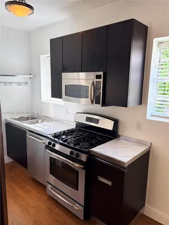a kitchen with granite countertop a stove and a microwave