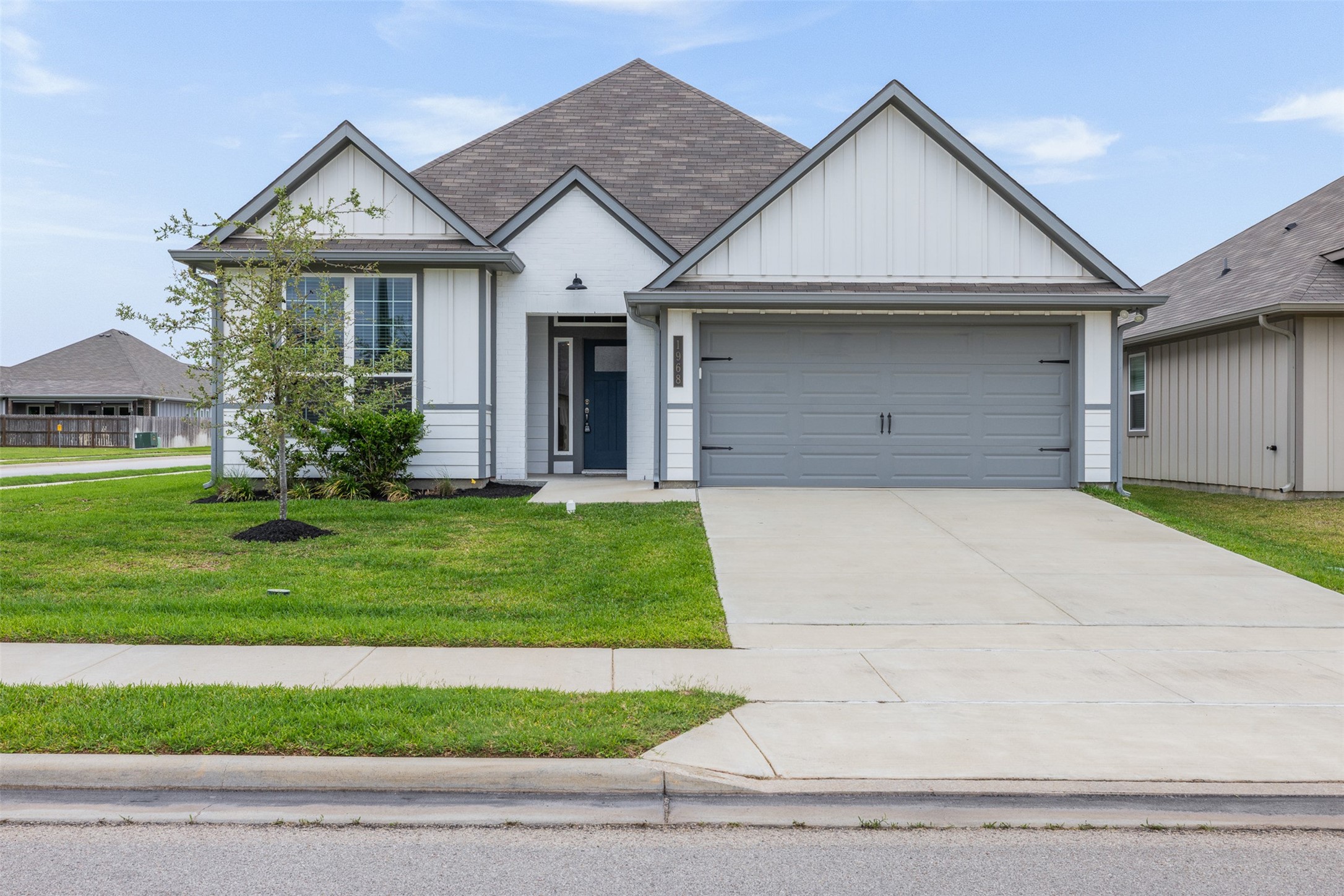 1968 Chief Street Bryan, TX 77807 - Photo 23 of 27 Modern single-story home featuring a clean, light exterior with a gabled roof and a two-car garage. The property is on a corner lot with well-maintained landscaping and a spacious driveway.