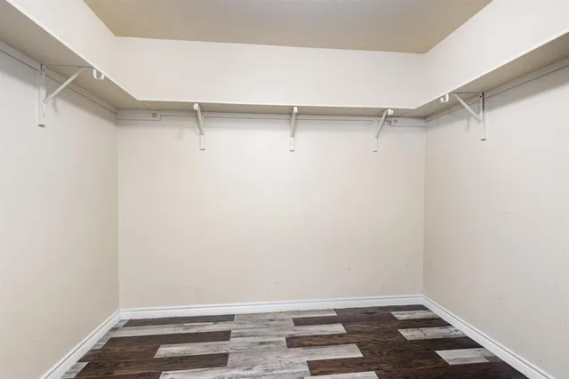 a view of walk in closet with empty racks