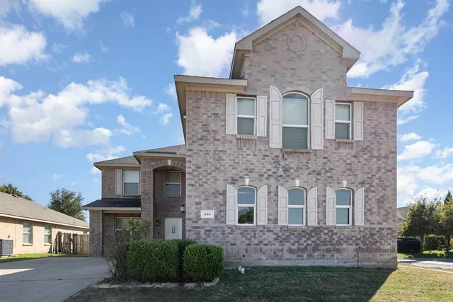 a view of a brick house next to a yard