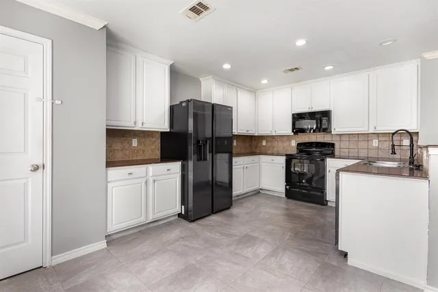 a kitchen with stainless steel appliances granite countertop a refrigerator stove microwave and sink