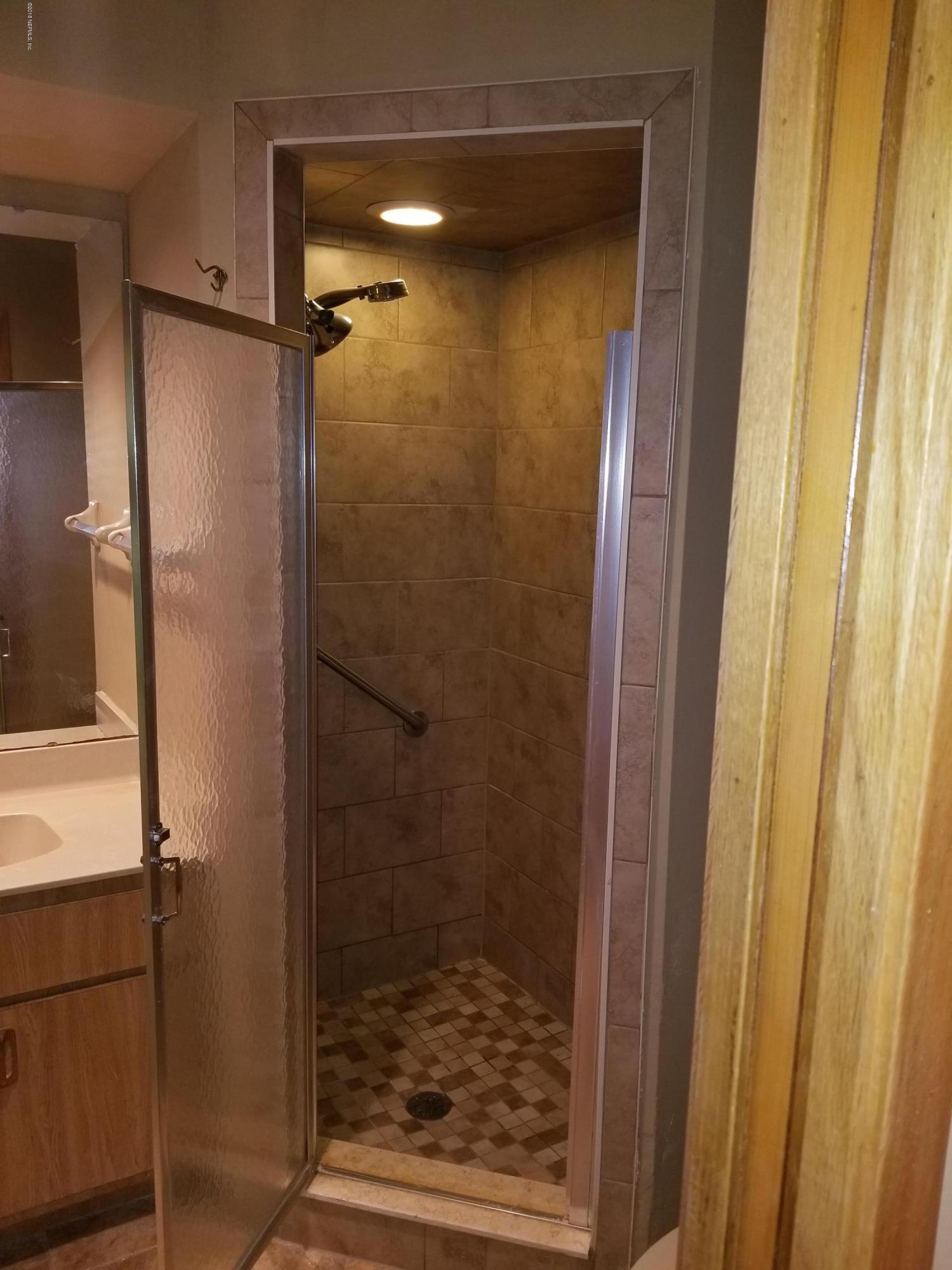 3175 Ravines Road, Unit 3703 Middleburg, FL 32068 - Photo 11 of 13 a bathroom with a glass door shower