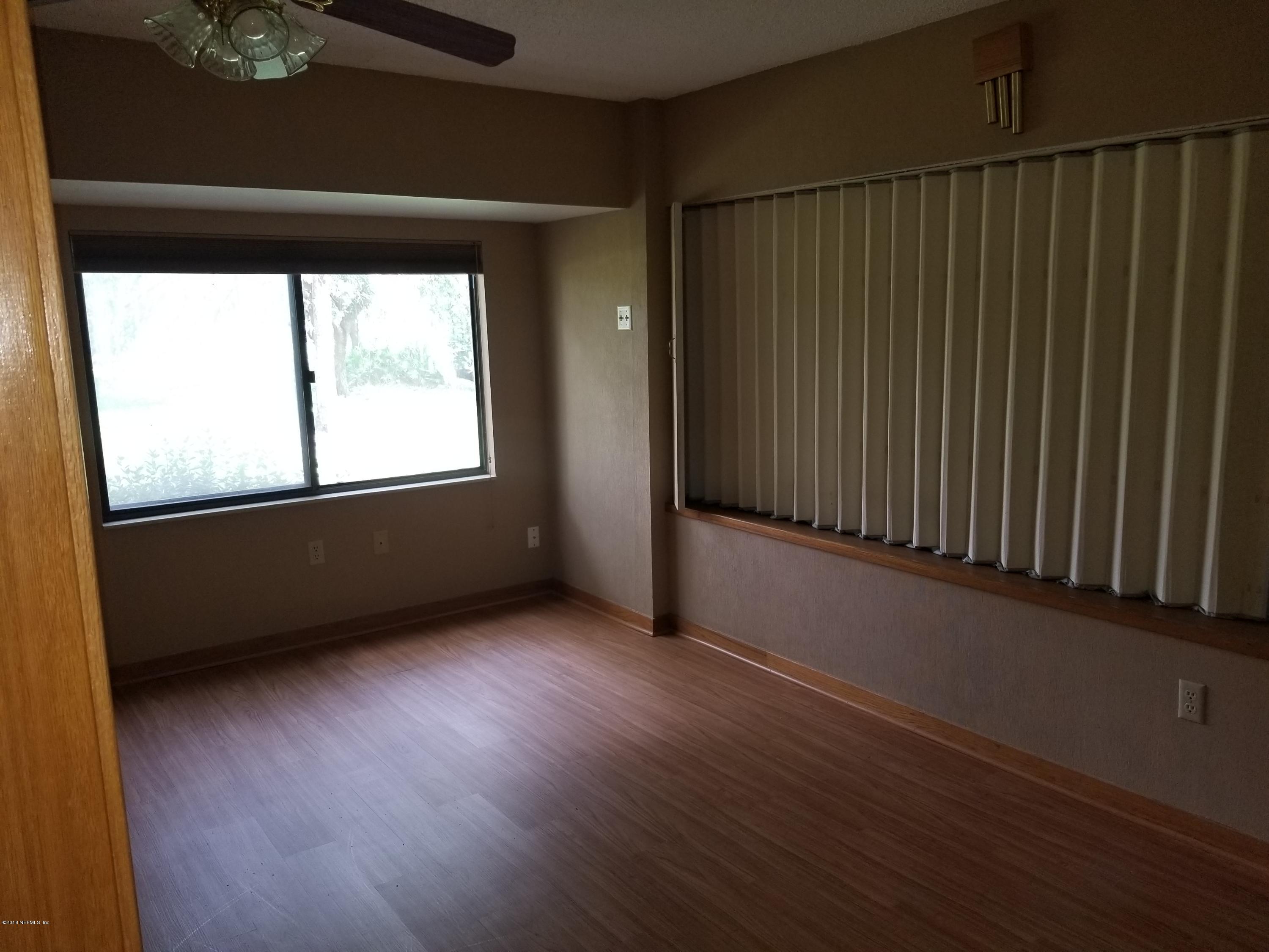 3175 Ravines Road, Unit 3703 Middleburg, FL 32068 - Photo 7 of 13 an empty room with wooden floor and windows