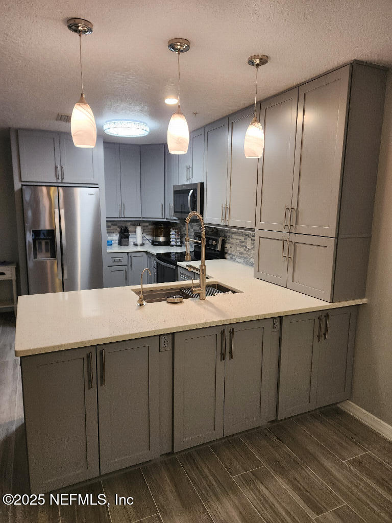 a kitchen with stainless steel appliances granite countertop a sink a microwave a refrigerator and island