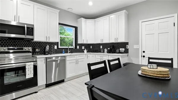 a kitchen with white cabinets stainless steel appliances and sink