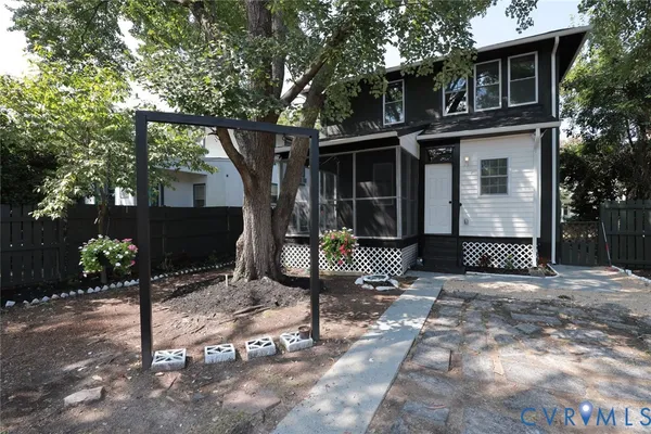 a backyard of a house with table and chairs and wooden fence