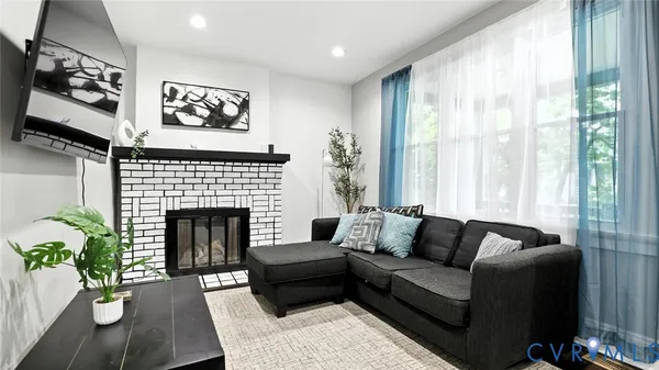 a living room with furniture a flat screen tv and a fireplace