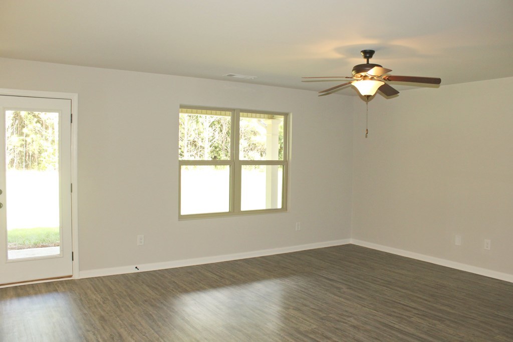 965 Weldon Road Forsyth, GA 31029 - Photo 2 of 11 an empty room with wooden floor fan and windows